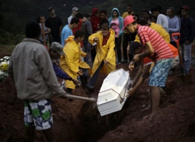 The casket of 9-year-old landslide victim Mauro Viana is lowered into the ground in Teresopolis, Brazil.