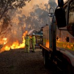 In this Sunday, Feb. 6, 2011, photo provided by the Fire and Emergency Services Authority of Western Australia, Gosnell bushfire brigade battles a fire at the rear of a house in the Perth, suburb of Roleystone. (AP Photo/FESA, Evan Collis)
