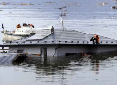 Divers search a house today which was swept into the sea by the 11 March tsunami.