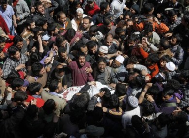 Kashmiri Muslims shout slogans as they crowd around the body of Moulvi Showkat Ahmed Shah