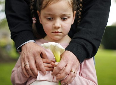 Katie Diamond, 5, holds an Easter Lily in her dad Finbarr Diamond's arms at Fianna Fáil's annual commemoration in Arbour Hill cemetery.