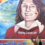 A woman passes a wall mural of Bobby Sands in west Belfast in 2006. Pic: AP Photo/Peter Morrison