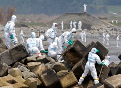 Fukushima police, wearing protective clothing, searching for missing people in the Fukushima Prefecture on 16 June, 2011.