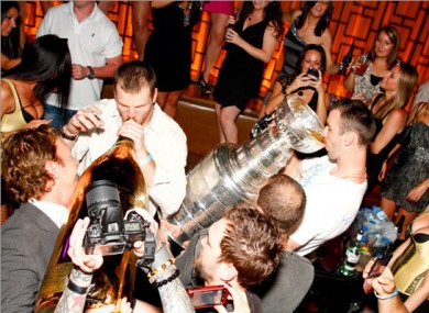 Zdeno Chara (right) drinks from the Stanley Cup as team mate Shawn Thornton necks a $100,000 bottle of bubbly.
