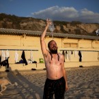 An ultra-Orthodox Jewish man takes an alternative shower at a gender-segregated beach in Tel Aviv, Israel (AP Photo/Oded Balilty)