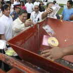 Filipinos throw pirated DVD's into a mechanised grinder during a ceremonial destruction of counterfeit goods seized in raids (AP Photo/Bullit Marquez)