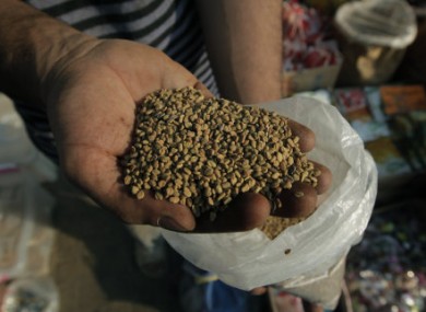 An Egyptian spice dealer displays fenugreek seeds at his shop in Cairo, Egypt