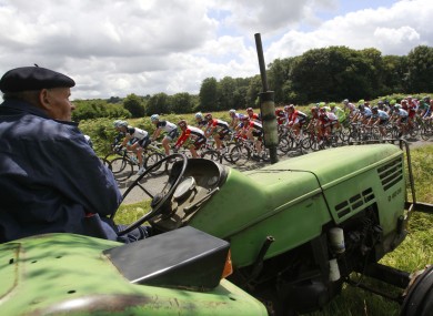 An elderly farmer watches the peleton pass by near Plougonver.