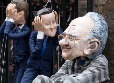 Puppets of Nick Clegg, David Cameron and Rupert Murdoch outside Murdoch's home in London this morning.