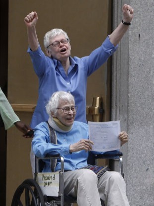 Phyllis Siegel, 76, and her wife Connie Kopelov, 84, (in wheelchair) celebrate becoming the first same-sex couple to be married at the Manhattan City Clerk's office yesterday