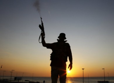 A Libyan rebel shoots in the air at a checkpoint in the Bab El Bahrah district in Tripoli yesterday.