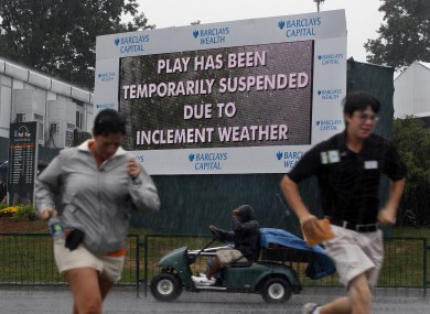 Spectators at The Barclay's run for cover during Thursday's first round.