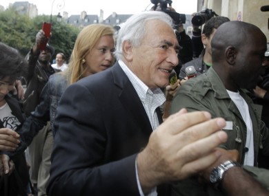 Dominique Strauss-Kahn and Anne Sinclair are crowded by media as they arrive back at their Parisian home.