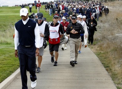 Tiger Woods leads the gallery down the second fairway during the first round of the Frys.Com Open golf tournament yesterday.