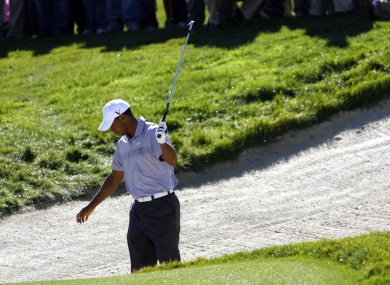 Woods looks unimpressed after escaping a bunker on the 13th hole of his second round.