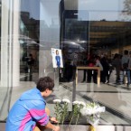 A young Chinese man leaves flowers for Steve Jobs outside an Apple store in Sanlitun, Beijing, China. (Zhang jusheng/AP/Press Association Images)