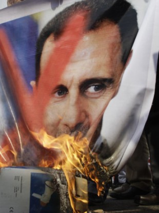 A portrait of Syria's president is set alight by anti-Assad protesters in Cairo on Saturday.