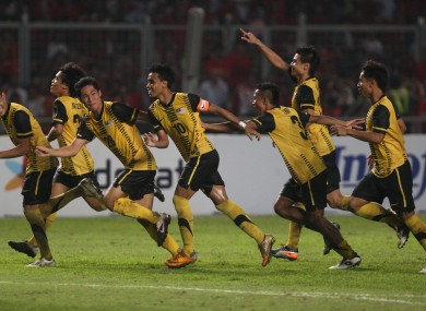 Malaysian players celebrate upon winning their SEA Games soccer final match against Indonesia, at Gelora Bung Karno in Jakarta, Indonesia, Monday, Nov. 21, 2011.