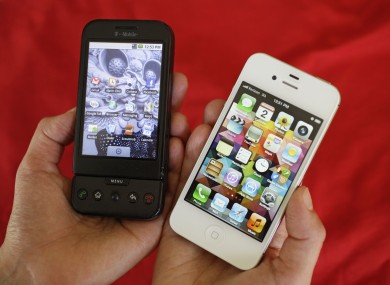 Shown at left is an HTC G1 smartphone offered by T-Mobile and at right is an Apple iPhone 4S smartphone in San Francisco