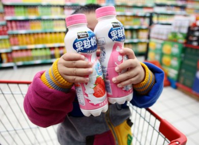 A child holds two bottles of strawberry-flavoured Pulpy Milky at a Shanghai supermarket