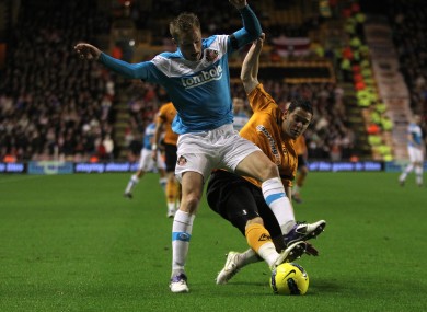 Sunderland's Sebastian Larsson buckles under a challenge from Matt Jarvis.