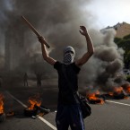 A demonstrator protests in front of tires set on fire in Buenos Aires, Argentina. (AP Photo/Natacha Pisarenko)