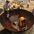 Hindu devotees wash a huge iron cooking pot at Sangam, the confluence of the rivers Ganges and Yamuna, during the annual Hindu religious fair of Magh Mela in Allahabad, India. (AP Photo/Rajesh Kumar Singh)
