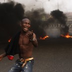 An angry youth protests in front of a burning barrier following the removal of a fuel subsidy by the government in Lagos, Nigeria. (AP Photo/Sunday Alamba)