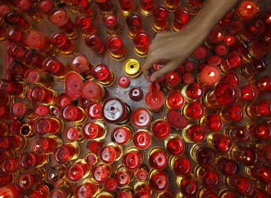 A Filipino-Chinese lights candles while praying inside a Chinese temple in celebration of the Chinese New Year at Manila's Chinatown district Monday Jan. 23, 2012 in the Philippines.