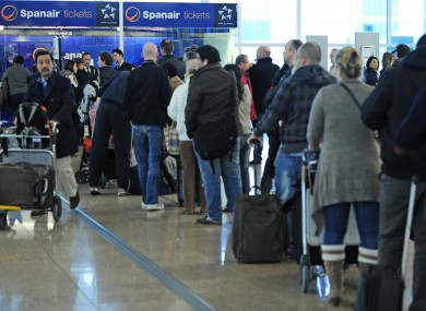 Passengers wait at a Spanair desk at Barcelona airport yesterday