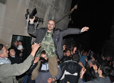 Anti-Syrian regime protestors hold up a Syrian army defector as they chant slogans during a protest in central Syria last night.