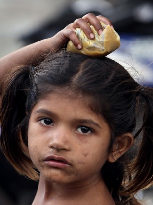 10 January 2012: An Indian child carries a plastic pouch containing food in Hyderabad, India