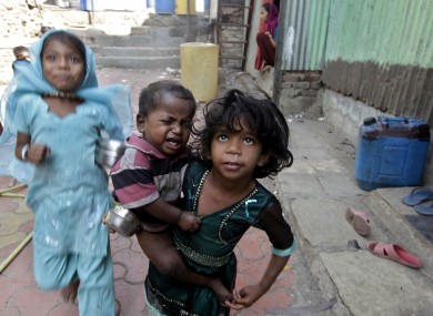 A girl holds a malnourished child outside the Apanalay center that works with malnourished children in Mumbai, India (File photo)