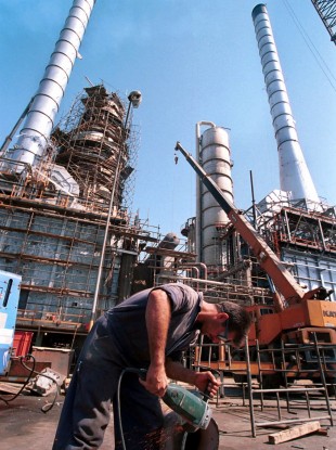 File photo shows an Iranian oil worker repairs a pipe at an oil refinery in Tehran
