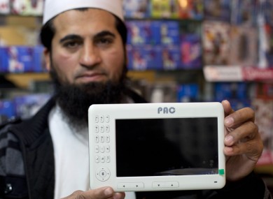 Mohammad Imran holds a Pakistani-made PACPad computer tablet at his electronics store in Rawalpindi, Pakistan