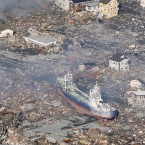 A large vessel is seen stranded among ruins in Kesennuma, Miyagi Prefecture a day after the tsunami struck. (Kyodo/PA Images)
