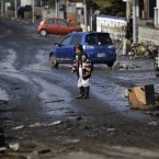 One woman stands on a street and inspects the aftermath of the massive tsunami triggered by the 11 March earthquake in Tagajo near Sendai, northern Japan. (AP Photo/Junji Kurokawa/PA Images)