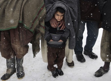 File photo: Internally displaced Afghans wait for blankets and winter clothing at a camp in Kabul, 20 February.