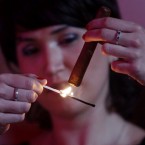 A woman lights her cigar at the annual cigar festival gala dinner in Havana, Cuba. (AP Photo/Javier Galeano)