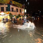 In this photo taken on Wednesday, March 7, 2012, a motorist drives through a flooded road in Kuala Lumpur, Malaysia. (AP Photo) 