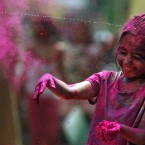 An Indian girl has her face smeared with colored powder during the festival of Holi. (AP Photo/Arun Sankar K.)