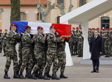 President Sarkozy stands by soldiers carrying a coffin during a ceremony to pay homage to the three soldiers.