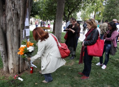 People lay flowers at the site where the elderly man shot himself today