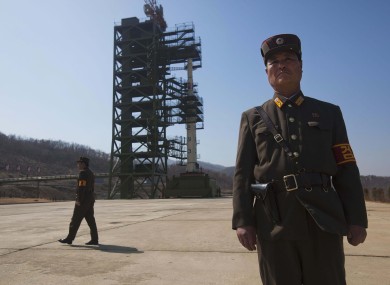 North Korean soldiers stand in front of the country's Unha-3 rocket before launch