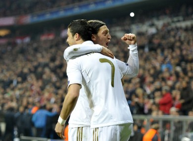 Real Madrid's Cristiano Ronaldo congratulates team mate Mesut Ozil on finding a spare jersey.