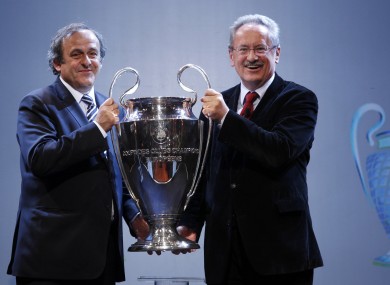 UEFA President Michel Platini, left, hands over the UEFA Champions League trophy cup to Mayor of Munich Christian Ude