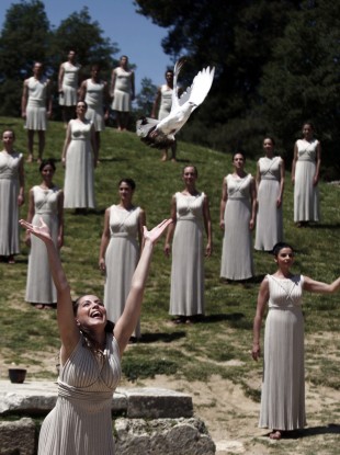The 'high priestess' carries the Olympic flame she has just lit using a concave mirror to concentrate the sun's rays.