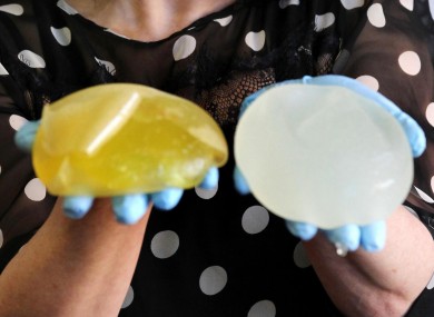 A woman whose PiP impants ruptured shows the removed implants.