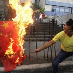 A protester burns a Chinese flag outside the Chinese consulate in suburban Makati, south of Manila, Philippines on Monday April 30, 2012. The Philippines and China are in a standoff over Scarborough Shoal which began early April after the Philippine navy accused Chinese boats of illegally fishing in the area. The Philippines says the shoal lies within its exclusive economic zone.(AP Photo/Aaron Favila)