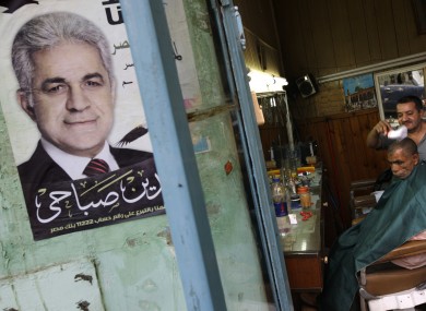 A campaign poster with the picture of Shafiq outside a barbershop in Cairo.